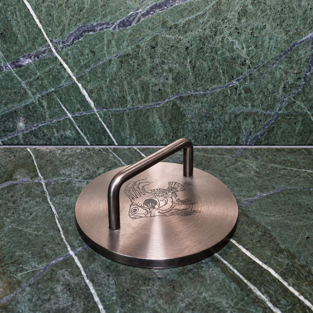 Bronze Fish Weight on green marble